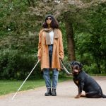 woman-in-brown-coat-and-blue-denim-jeans-standing-beside-a-guide-dog-8327845 guide_dog_1682661248.jpeg MART PRODUCTION at Pexels