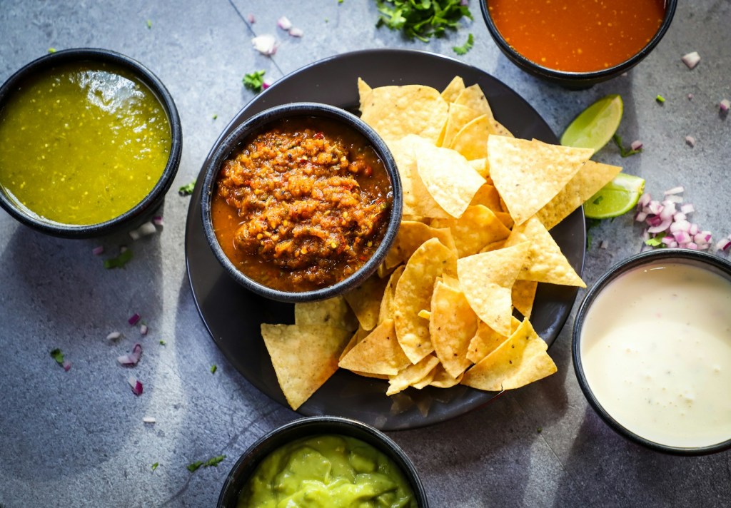 a plate of chips, salsa, and guacamole on a table.jpg