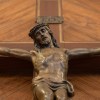 a bronze statue of jesus on a wooden cross.jpg