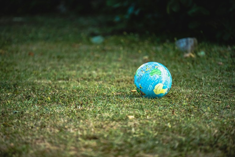 blue and white desk globe on green grass field during daytime.jpg