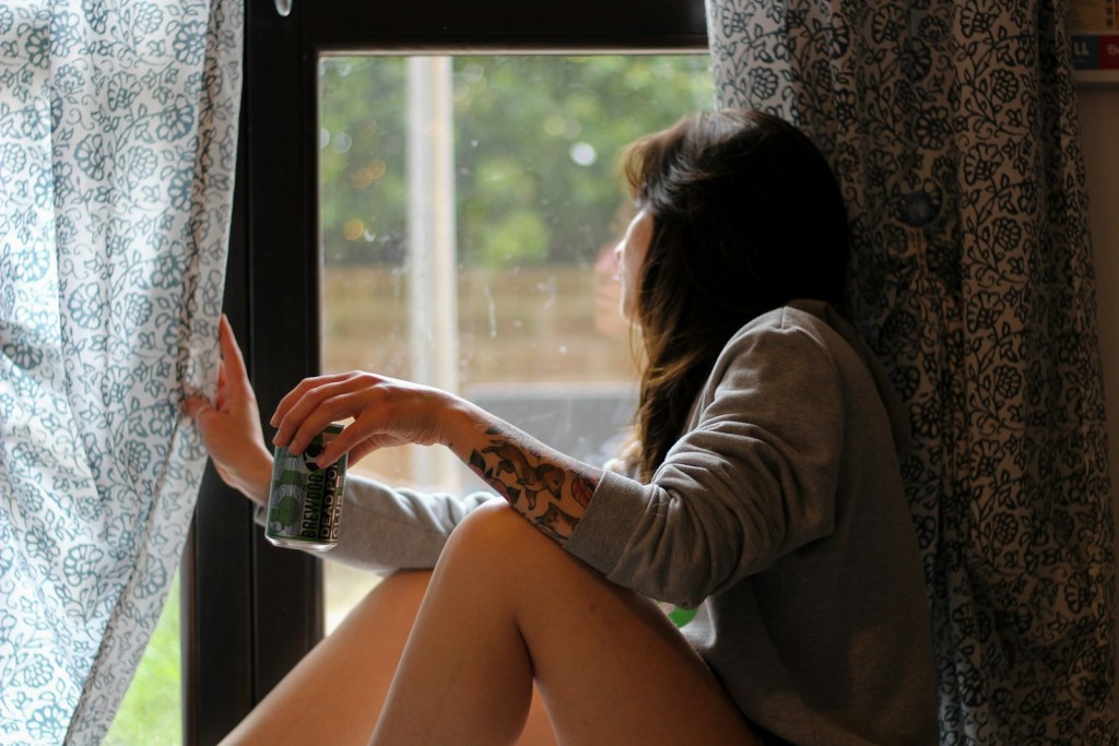 shallow focus photo of woman in gray long-sleeved shirt beside window.jpg