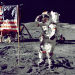 astronaut standing on moon beside U.S.A. flag.jpg