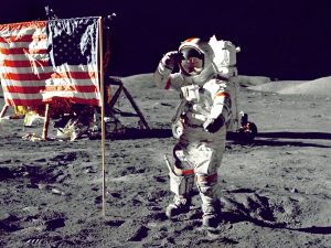 astronaut standing on moon beside U.S.A. flag.jpg