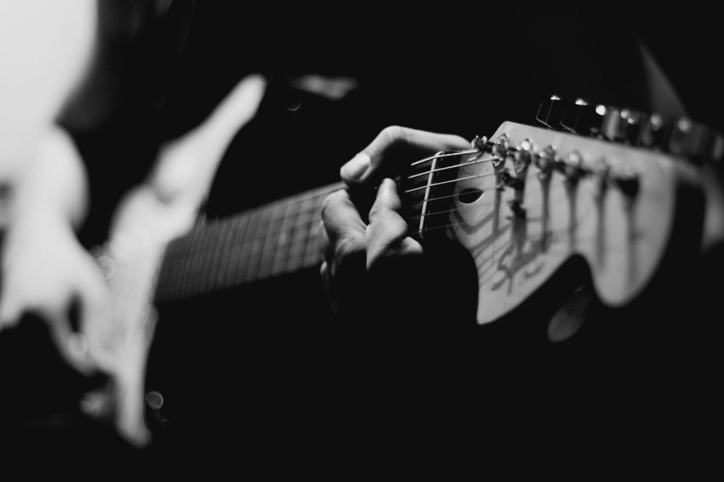 grayscale photography of person playing electric guitar.jpg