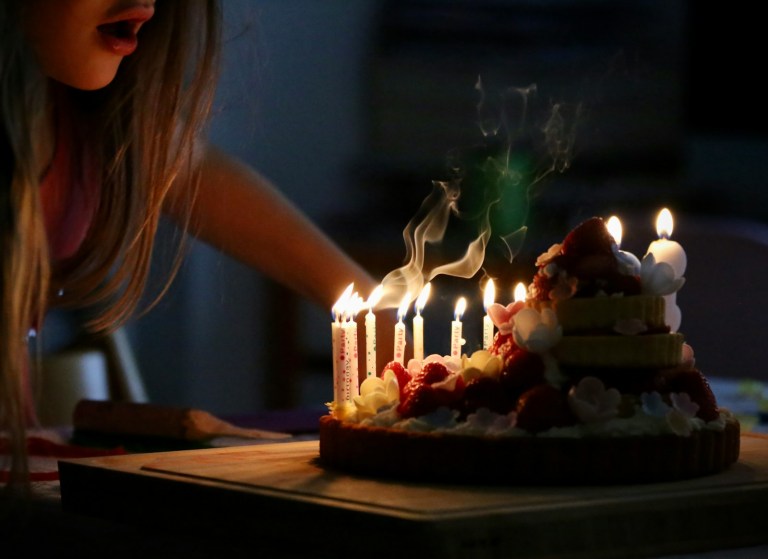 woman in white tank top holding lighted candles.jpg