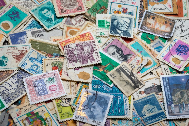 assorted postage stamps on blue and white textile.jpg