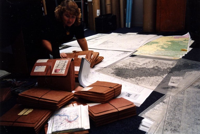 c.1997. Suzanne Wiley preparing paper maps for aerial survey use. Individual maps were cut and taped together to create logical flight groups that, together, covered the forested areas of Oregon and Washington.jpg