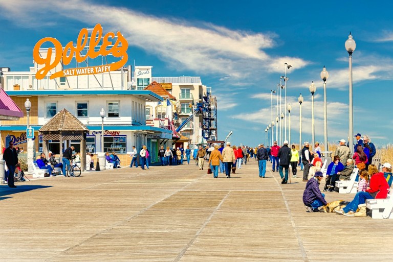a group of people walking on a boardwalk next to a building.jpg