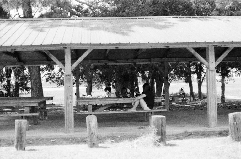 a black and white photo of a person sitting on a bench.jpg