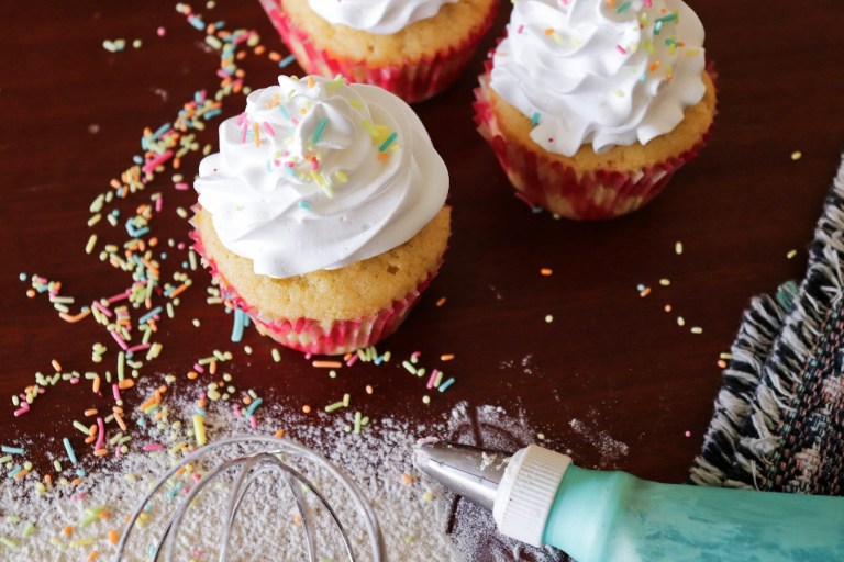 three cupcakes with white frosting and sprinkles.jpg