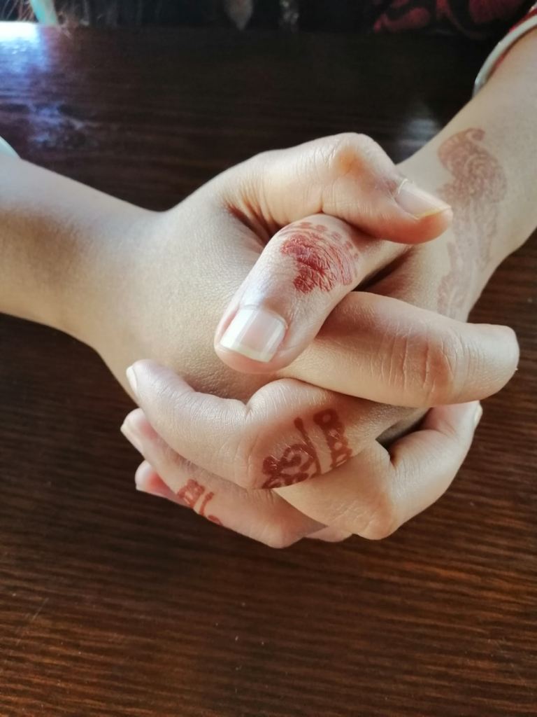 person's hands with red mehndi tattoos.jpg