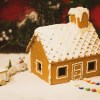 a gingerbread house with a train and a christmas tree in the background.jpg