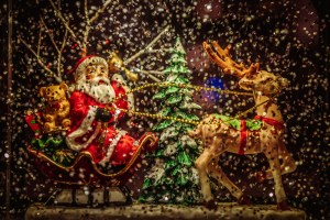 Santa Claus riding sleigh holding rope of reindeer figurine.jpg