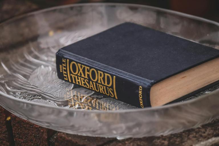 Elegant hardcover thesaurus with classic design on a textured glass plate..jpg