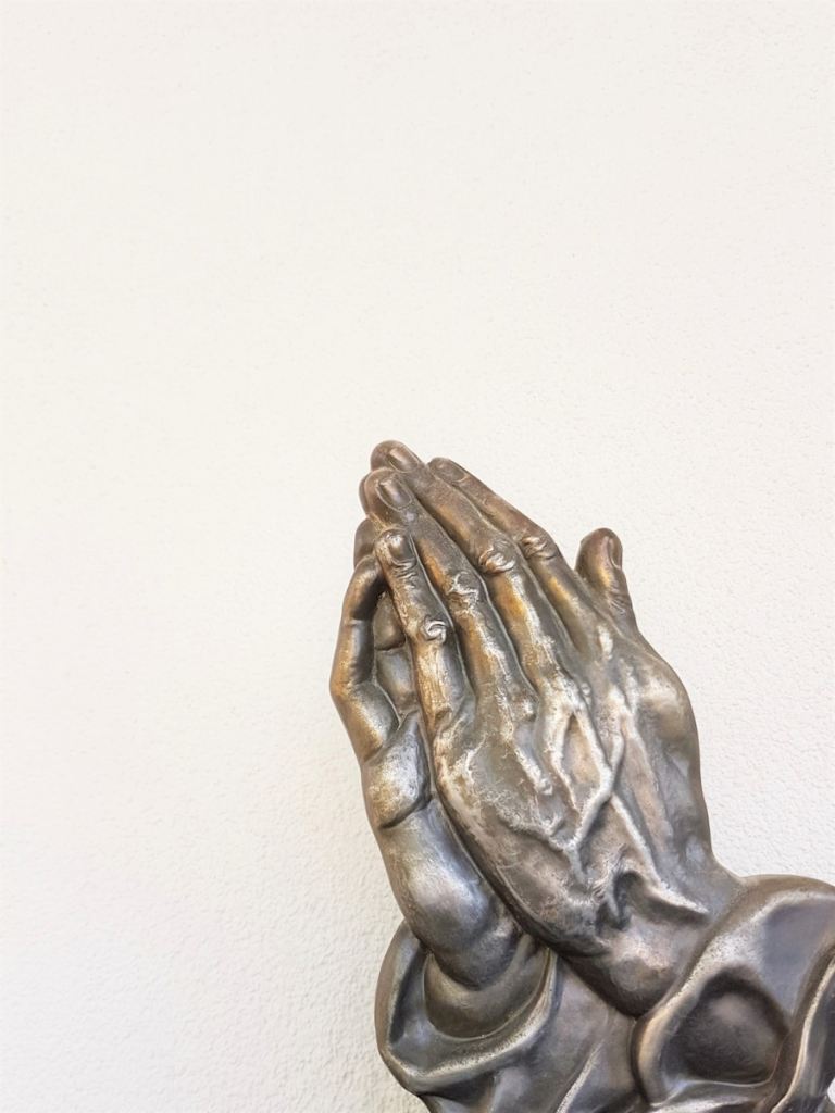 gray praying hand statue.jpg