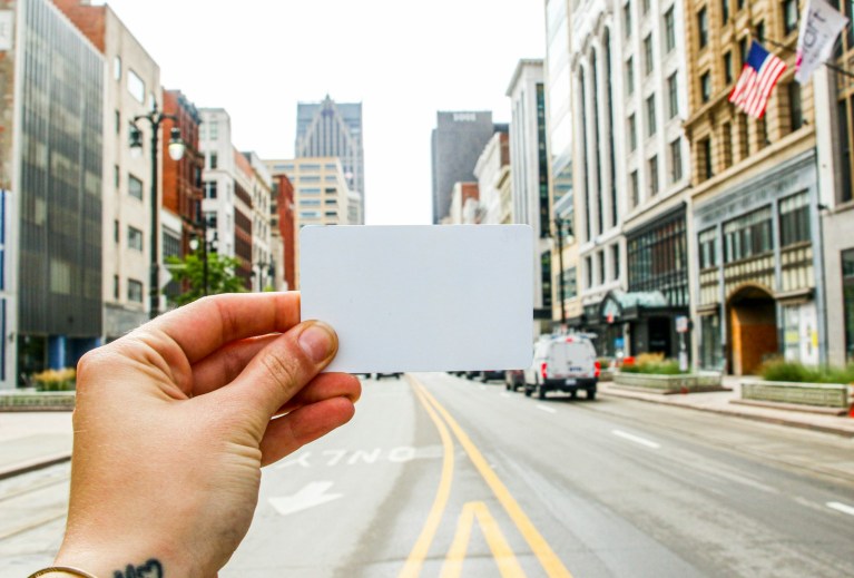 a person holding a business card in the middle of a street.jpg