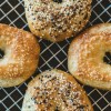 four bagels with sesame seeds on a cooling rack