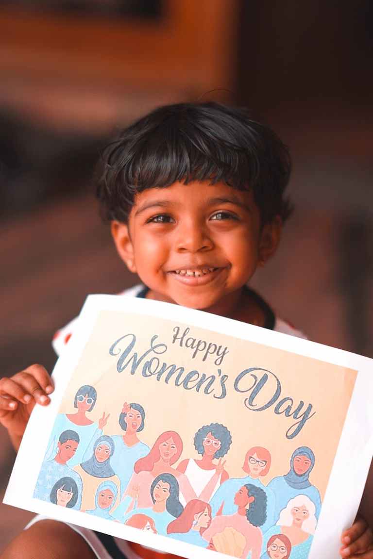 A joyful child holding a Happy Women's Day poster celebrating diversity and empowerment..jpg