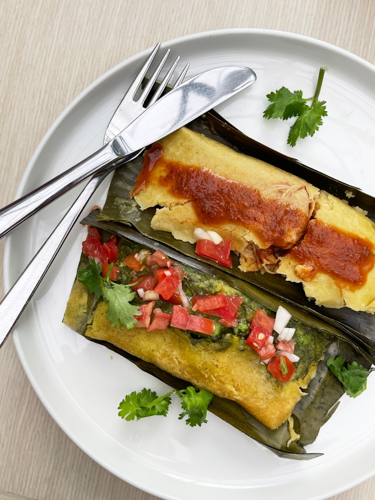 A white plate topped with two enchiladas and a fork.jpg