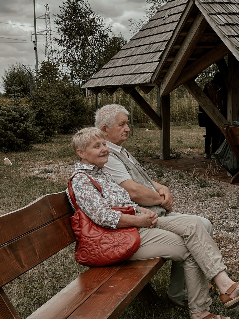 a man and a woman sitting on a wooden bench.jpg