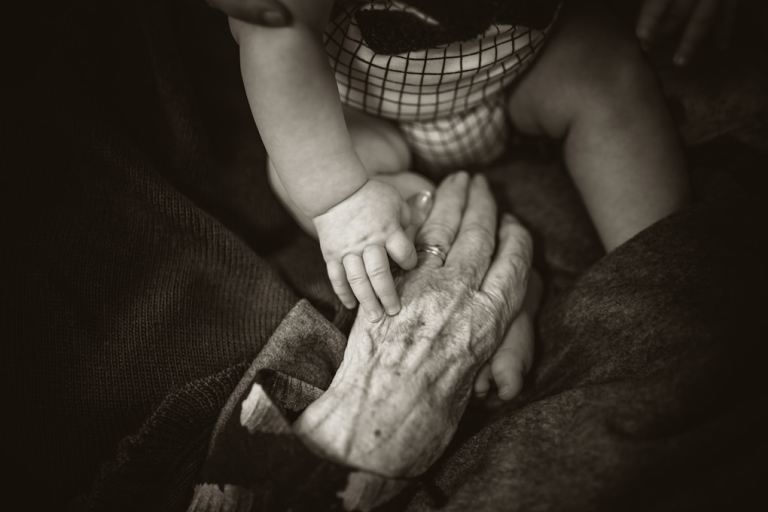an older woman holding a baby's hand.jpg