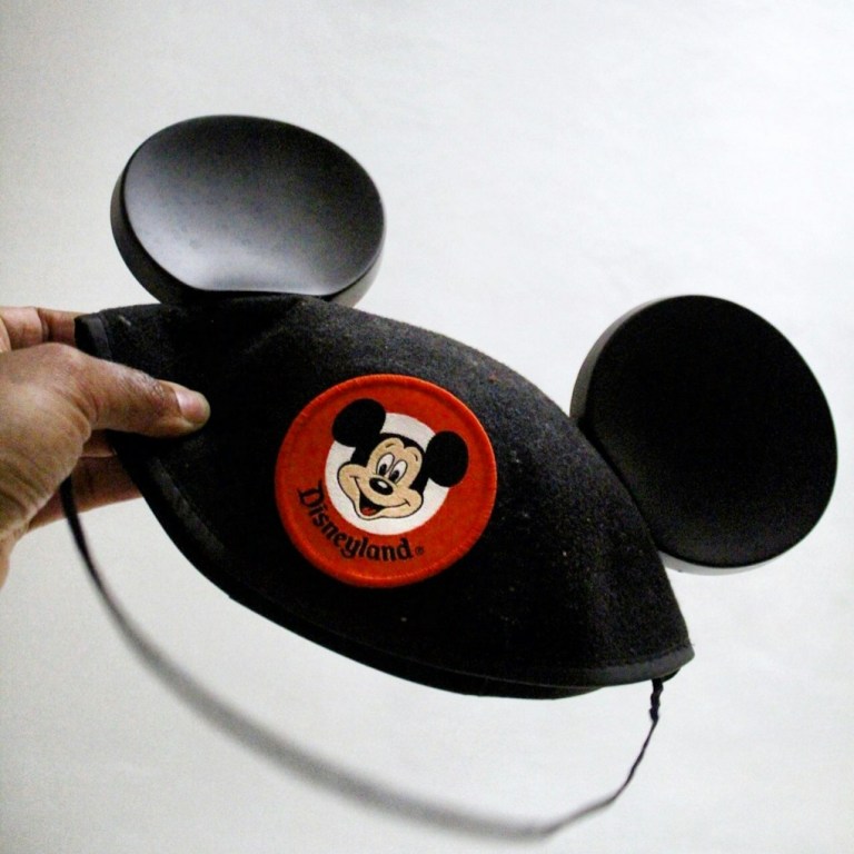 person holding Mickey Mouse cap.jpg