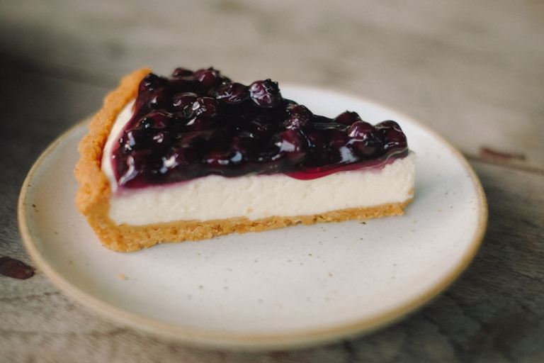 slice blueberry cheesecake pie on white ceramic plate.jpg
